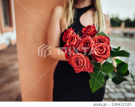 Woman is holding a bouquet of red roses 126412185