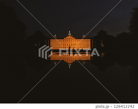 A large building with a large dome on top is lit up at night 126412242