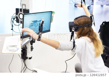 Woman on stand with virtual reality device for rehabilitation Woman on stand with virtual reality device for rehabilitation 126412857