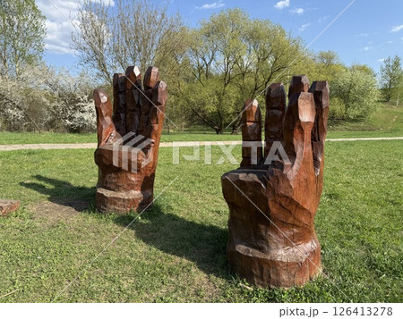 Two Wooden Armchairs Sculpted as Giant Hands in Park 126413278