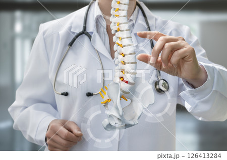 Doctor demonstrates spine anatomy in modern clinic 126413284
