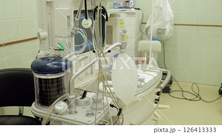Medical ventilator supporting patient breathing, positioned in sterile operating room, facilitating critical surgical intervention with advanced respiratory technology 126413333