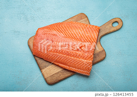 Fresh raw salmon fillet lying on wooden cutting board 126413455