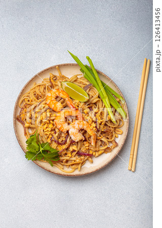 Traditional dish of Thailand, Pad Thai noodles with shrimps and peanuts on a plate top view. South Asian cuisine 126413456