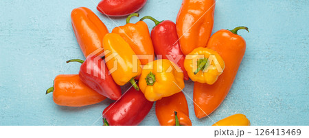 Sweet mini peppers lying on a blue tabletop Sweet mini peppers lying on a blue tabletop 126413469