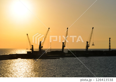 Abstract silhouette of container and gantry crane at port on evening and sun flares background. 126413538