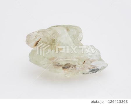 A raw, uncut specimen of pale green beryl crystal showcased against a clean, neutral background, highlighting its natural formations and internal inclusions mineralogy, geology, transparency A raw, uncut specimen of pale green beryl crystal showcased against a clean, neutral background, highlighting its natural formations and internal inclusions mineralogy, geology, transparency 126413868