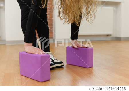Young woman stretching with yoga blocks indoors. Young woman stretching with yoga blocks indoors. 126414038