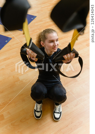 Young woman training with trx fitness straps in the gym. 126414043