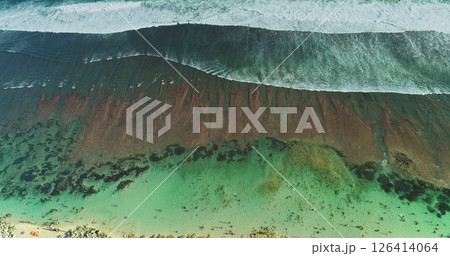 Stunning drone footage captures the mesmerizing beauty of turquoise ocean waves gracefully crashing onto the shore, revealing a captivating blend of colors and textures beneath the surface Stunning drone footage captures the mesmerizing beauty of turquoise ocean waves gracefully crashing onto the shore, revealing a captivating blend of colors and textures beneath the surface 126414064