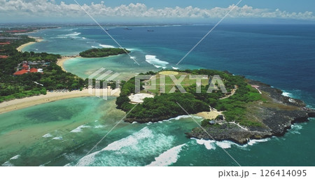 Capturing aerial views of a tropical Bali island, featuring lush vegetation, pristine white sand beaches, and crystal-clear turquoise waters with dynamic breaking waves 126414095