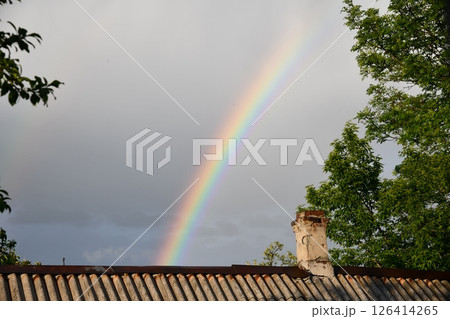 The end of a rainbow with a field in foreground 126414265