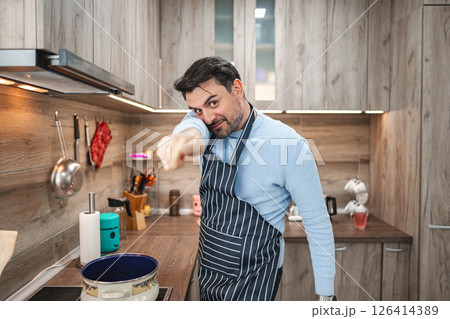 Man in the kitchen having fun while cooking Man in the kitchen having fun while cooking 126414389