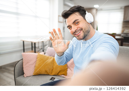 Selfie of brown-haired smiling man with white headphones 126414392