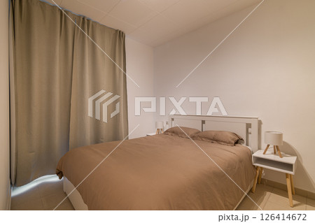 Full view of minimalist bedroom with white bed frame, neutral bedding and two small nightstands Full view of minimalist bedroom with white bed frame, neutral bedding and two small nightstands 126414672