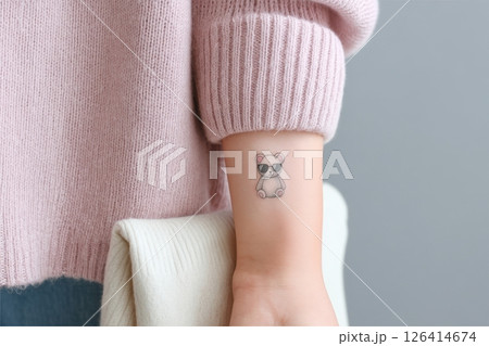 Tiny tattoo of a teddy bear wearing sunglasses, minimalist and cute design on a persons forearm 126414674