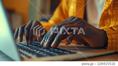 Close-up of hands typing on a laptop keyboard in a modern workspace 126415518