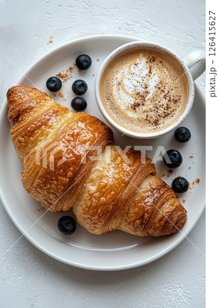 Delicious Breakfast with Croissant, Blueberries, and Cappuccino on White Plate 126415627