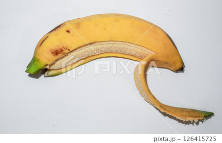 Ripe banana peeled in half on a white background. Concept of fresh tropical snack, healthy food. 126415725