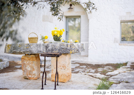 Stone table with lemons and flowers 126416029