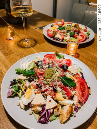 Fresh vegetables with egg and pesto, vegetables combined with cheese and herbs, vegetables artfully served on plate. Leafy greens with tomato, egg and croutons, greens and toppings create health plate 126416409