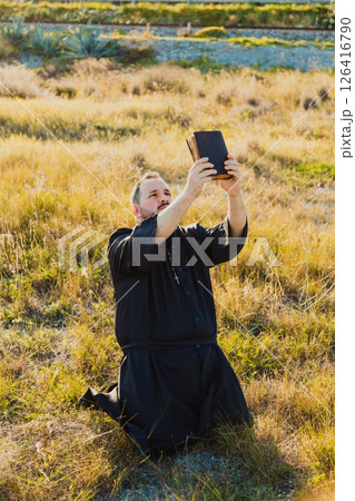 Priest On His Knees In The Nature With The Bible Priest On His Knees In The Nature With The Bible 126416790