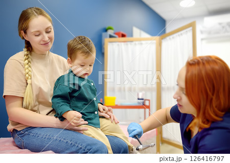 A cute toddler boy with his mother are at an appointment with a pediatric neurologist A cute toddler boy with his mother are at an appointment with a pediatric neurologist 126416797