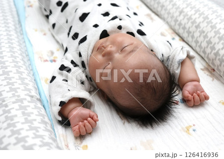 バンザイの格好で寝る生後3ヶ月の女の子の赤ちゃん バンザイの格好で寝る生後3ヶ月の女の子の赤ちゃん 126416936