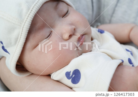 寝ている生後3ヶ月の女の子の赤ちゃんの口からよだれの泡が出ている 126417303