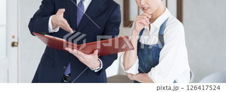 物件案内する不動産営業マンと開業する女性 126417524
