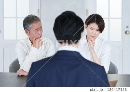 打ち合わせする営業マンと親子の客 126417528