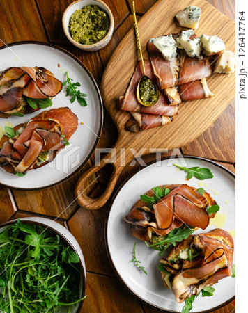Toasts or bruschettas with bacon, fresh arugula, pesto sauce and blue cheese. 126417764