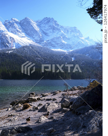 Majestic snow-capped mountains reflect in the tranquil lake during a sunny winter day Majestic snow-capped mountains reflect in the tranquil lake during a sunny winter day 126417974