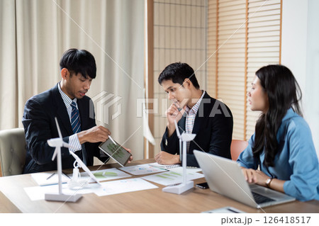 Sustainability and ESG Focus. Professionals reviewing environmental data and strategies in a collaborative meeting. Sustainability and ESG Focus. Professionals reviewing environmental data and strategies in a collaborative meeting. 126418517