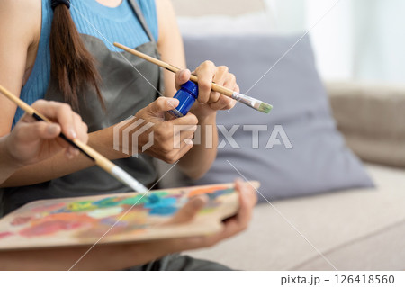 Lesbian couple bonding over a painting activity at home 126418560