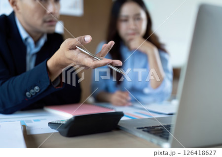 Focused Business Discussion. Professionals analyzing data and discussing strategies in a modern office. 126418627