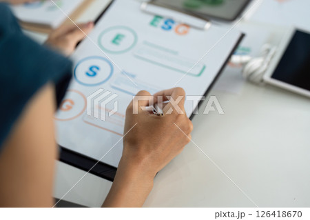 ESG Focus. Individual analyzing Environmental, Social, and Governance metrics on a clipboard. ESG Focus. Individual analyzing Environmental, Social, and Governance metrics on a clipboard. 126418670
