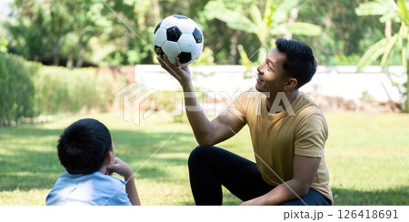 Wellness through playful interaction: Father teaches son soccer skills Wellness through playful interaction: Father teaches son soccer skills 126418691