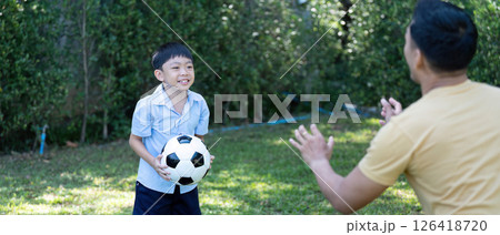 Wellness and happiness: Young boy playing soccer with father Wellness and happiness: Young boy playing soccer with father 126418720
