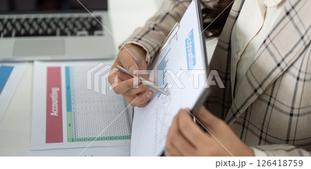 Financial Reporting and Analysis. Business professional reviewing charts and data on clipboard. Financial Reporting and Analysis. Business professional reviewing charts and data on clipboard. 126418759