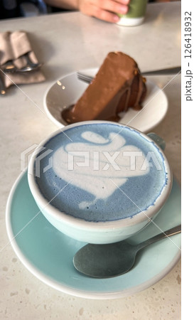 Delicious Dessert Indulgence Blue Matcha Latte Art and Chocolate cheesecake Delight on Tabletop 126418932