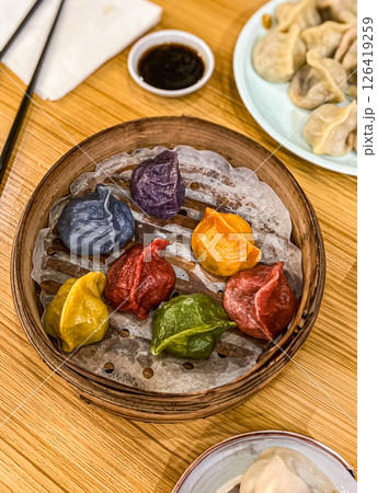 Traditional colourful Chinese dim sum dumplings in a wooden bowl with chopsticks 126419259