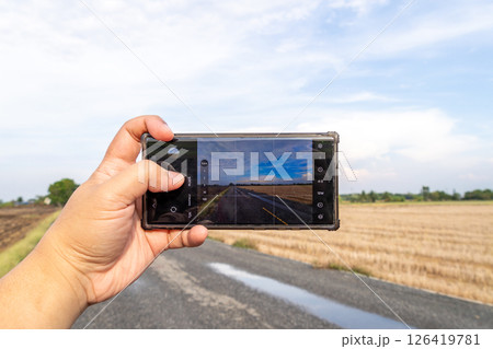 Capturing a scenic road landscape rural area smartphone open space handheld travel inspiration 126419781