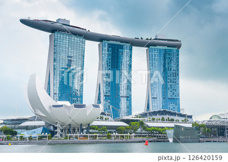 Singapore, Singapore - 4 April 2025: Iconic Marina Bay Sands hotel and ArtScience Museum under cloudy sky in Singapore. Modern architecture by the waterfront. 126420159