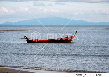 Fishing boat anchored tranquil shoreline scenic beach coastal landscape serene view Fishing boat anchored tranquil shoreline scenic beach coastal landscape serene view 126420189