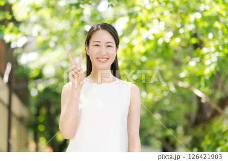 公園でピースをする女性 126421903