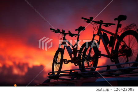 Two Mountain Bikes on Car Roof at Sunset 126422098