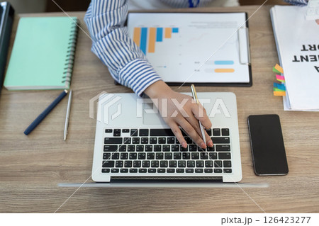 Remote Work and Digital Transformation. Close-up of professional woman using laptop for data analysis. 126423277