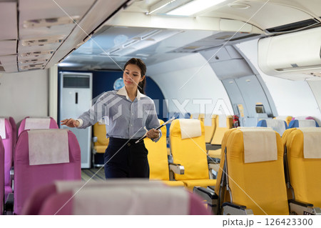 Business travel preparation with airline staff checking passenger seating Business travel preparation with airline staff checking passenger seating 126423300