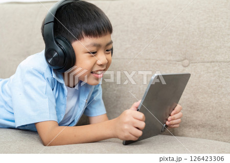 Back to School: Young Boy Engaged in Learning with Tablet and Headphones 126423306